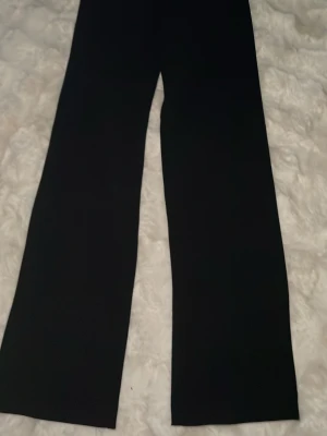 Svarta vida byxor från Vero Moda - Säljer ett par svarta kostym byxor från Vero Moda med rak och vid passform. Byxorna har en enkel design utan synliga detaljer och är tillverkade i ett mjukt tyg som ger en skön känsla. Perfekta för en avslappnad och trendig stil. Änvända 2-3 gånger. Storlek xs/34 Pris 250kr