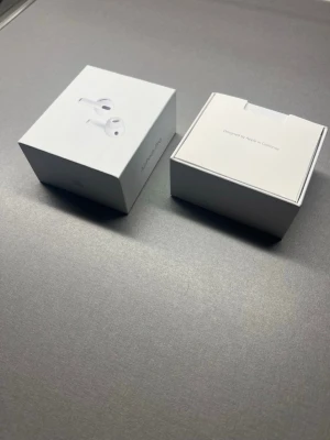 Apple AirPods Pro trådlösa hörlurar - Säljer ett par vita Apple AirPods Pro med laddningsetui. De är trådlösa in-ear hörlurar med stilren design och silikonproppar för bra passform. Kommer i originalförpackning med tillbehör och manual. Perfekta för musik, samtal och träning.