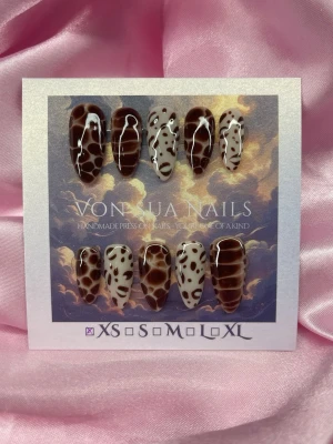 Feral (XS);Medium Almond - Handgjorda press-on naglar i olika djur print design. Mix av bruna och beiga nyanser med fläckigt mönster och glansig finish. Medium långa, mandelformade naglar i storlek  XS: 14 mm, 11 mm, 11,5 mm, 10 mm, 8 mm 
