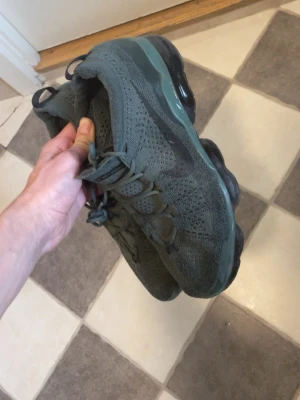 Nike Air Vapormax gröna sneakers - Pris kan diskuteras) Säljer ett par Nike Air Vapormax sneakers i olivgrönt med stickad ovandel och genomskinlig, bubblig sula. Skorna har klassisk Nike Swoosh på sidan och snörning framtill. Perfekta för dig som gillar streetwear och vill ha något bekvämt och snyggt.