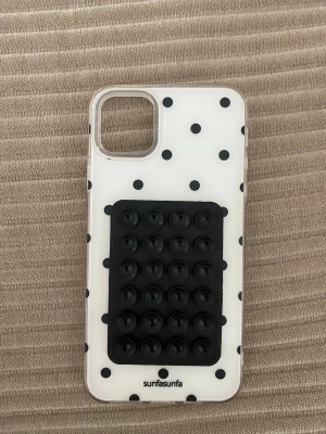 Prickigt mobilskal iPhone 11pro max - Snyggt genomskinligt mobilskal med svarta prickar och en svart pop it-detalj på baksidan. Passar iPhone 11PMax. Skalet är gjort i tålig plast och ger både skydd och en unik look till din mobil. Sugprops saken har jag själv satt till