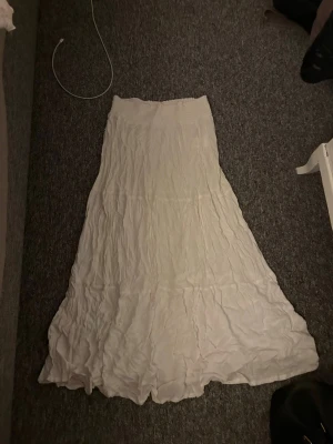 Vit lång volangkjol - Säljer en vit lång volangkjol från lager 157, aldrig använd och den är i storlek S 