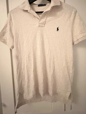 Ljus polo piké från Ralph Lauren - Klassisk vit pikétröja från Polo Ralph Lauren med korta ärmar. Väldigt passande till vår/sommar. Tröjan S/M