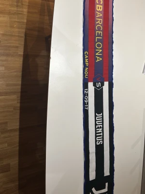 Barcelona vs Juventus halsduk - Säljer en supporterhalsduk från matchen FC Barcelona mot Juventus på Camp Nou, 12-09-17. Halsduken har Barcelonas rödblå färger på ena sidan och Juventus svartvita på andra, med text och klubbnamn invävt. Perfekt för fotbollsfans! En match där Messi gjorde 2 mål!