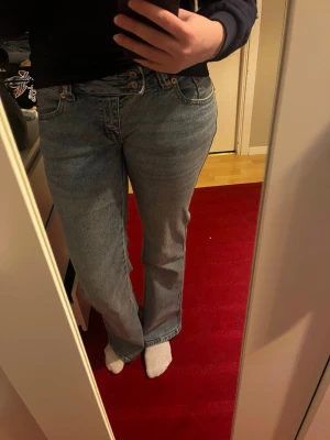 Ljusblå lågmidjade raka/flare jeans  - Säljer ett par ljusblå jeans från Lager 157 med raka/flare ben och låg midja. Jeansen har dubbla knappar i midjan och är tillverkade i ett mjukt denimtyg. Jätte fint broderi på bakfickorna. Strl S, short length. Kommer precis ner t fötterna på mig som är 165.Perfekta för vardagen. Använda endast ett par ggr.🩵