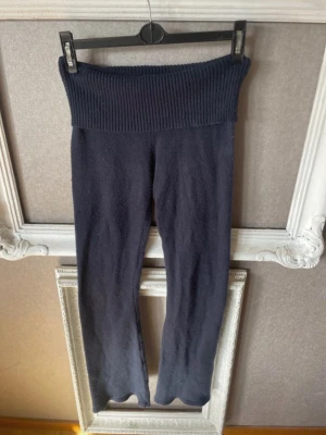 Mörkblå ribbade leggings - Säljer ett par mörkblå leggings med bred ribbad midja och booth cat. Materialet är mjukt och stretchigt