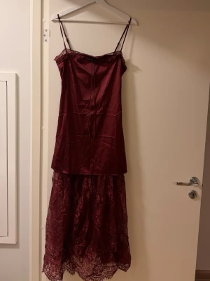 Vinröd klänning i satin med spets  - Otrolig klänning i satin med spets nedtill. Oanvänd, inköpt i Mexiko i en lokal butik. Märket är amerikanskt. Passar inte min kroppstyp vilket är så tråkigt då den är helt otrolig 🥲dragkedja bak, går till ca 3/4 av vaden på mig som är 170 cm. Storlek M men skulle säga att det är en liten M/större S. KÖP KÖP KÖP!! 