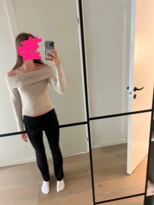 Beige off shoulder stickad tröja - Trendig beige stickad tröja med bred off shoulder-krage och åtsittande passform. Perfekt för dig som vill ha en stilren och modern look. Långa ärmar och mjukt material som känns skönt mot huden.