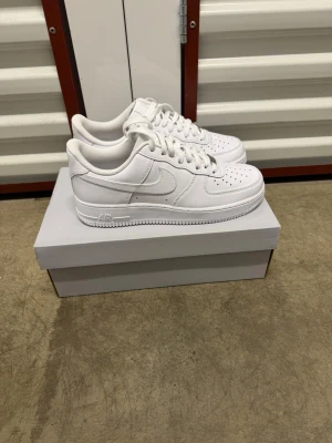 Nike Air Force 1 '07 Vita Sneakers strl 42. - Helt nya oanvända Nike Air Force 1 '07 Vita Sneakers strl 42.  Skorna har inte blivit använda eller testade. Original kartong medföljer! Nypris hos Nike 1400 kr
