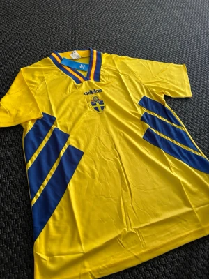 Svenska landslagströja Adidas gul/blå - Klassisk Vm 94 hemma tröja i storlek L. Den är helt ny med prislappRökfritt hem, djurfritt hem✅ Skickar inom 24h✈️ Har du några frågor eller vill ha fler bilder är det bara att kontakta mig📱 Pris kan diskuteras!