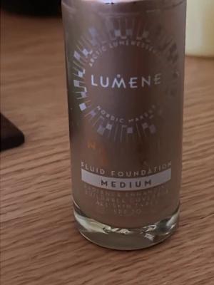 Lumene Fluid Foundation Medium - Lumene Fluid Foundation i nyansen Medium ger en naturlig finish och har en lättflytande formula. Kommer i en genomskinlig glasflaska med silverdetaljer. Passar dig som vill ha en buildable täckning och en fräsch look. Innehåller SPF 20.innehåller ca 80% av produkten