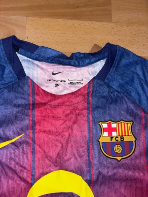 Nike FC Barcelona Spotify S ⚽ - Brand new Nike FC Barcelona 2022/23 Special Edition jersey, featuring a unique blue and red fading stripe design. This men's size S shirt includes the Spotify sponsor on the front, UNHCR/ACTUAR on the back, and UNICEF/Ambilight on the sleeves, all in vibrant yellow. Made with Nike's high-performance DRI-FIT ADV technology, it's perfect for fans or collectors.  ⭐️ Condition : 10/10 (New with tags) 🎲 Size : S 🎨 Color : Blue / Red / Yellow 📦 Fast and careful shipping.