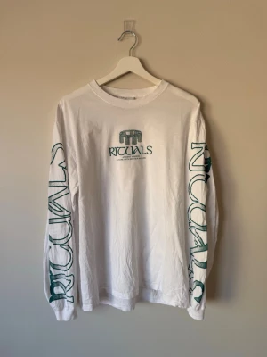 Långärmad t-shirt från Valient - Vit långärmad t-shirt från Valient med tryck på bröstet, ryggen och båda ärmarna. Har släppt en tråd i halsringningen (se sista bilden) därav priset! 