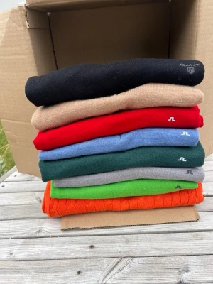 Stickade tröjor från Gant & J.Lindeberg - Säljer ett gäng stickade tröjor i olika färger från Gant och J.Lindeberg. Tröjorna har V-ringning och finns i svart, beige, röd, blå, grön, grå, orange och limegrön. Klassisk design med diskret logga på bröstet. Köp hela bulken för 2199 eller 399kr/st!