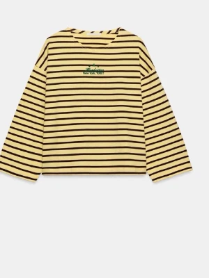 Randig långärmad topp i bomull - Gul och svart randig långärmad topp med croppad passform. Toppen har broderad grön text och motiv på bröstet där det står 'New York, 10001'. Tillverkad i mjuk bomull och har en avslappnad, loose fit.