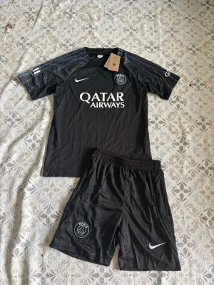 Svart PSG träningsset från Nike - Psg fotbollsträningsset i storlek S. Shortsen har fickor med dragkedjor. Helt nya och oanvända, Hör gärna av vid frågor!