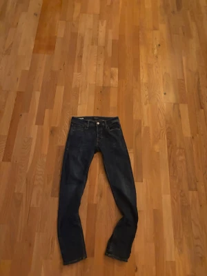 Mörkblå raka jeans - Snygga mörkblå jeans med klassisk rak passform och fem fickor. Jeansen har en enkel design utan synliga loggor och är tillverkade i ett robust denimtyg. Perfekta för dig som gillar en tidlös och clean look.