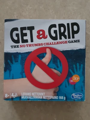 Get a Grip sällskapsspel - Säljer sällskapsspelet Get a Grip – The No Thumbs Challenge Game från Hasbro. Spelet går ut på att klara olika utmaningar utan att använda tummarna. Passar för 2 eller fler spelare från 8 år. Innehåller spelkort, utmaningar och tillbehör.