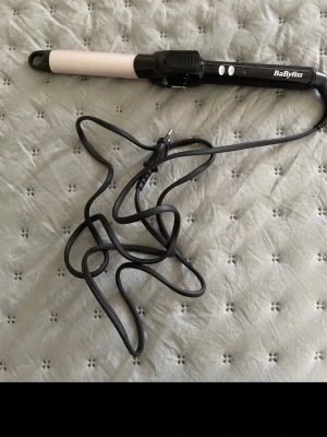 Locktång från BaByliss svart/rosa - Locktång från BaByliss med svart handtag och ljusrosa värmecylinder. Utrustad med klämma och två knappar på handtaget. Sladd med EU-kontakt. Perfekt för att skapa snygga lockar och vågor i håret. Vet tyvärr inte vilken storlek det är. Säljer endast för jag inte vet hur man använder den. Skriv gärna prisförslag. Hämtas i Vårberg 