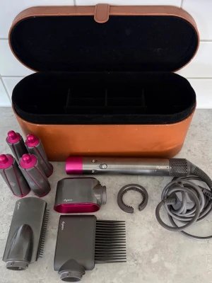 Dyson Airwrap med tillbehör och väska - Säljer min dyson airwrap då den inte kommer till använd längre. Funkar jätte bra. Orangea boxen har defekter men torken och tillbehören funkar jätte bra. Pris kan diskuteras. Kan hämtas i Hovås. Har tappat bort kvitto. 