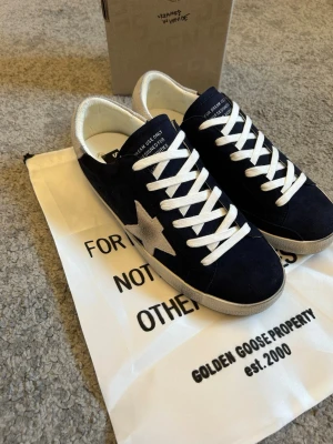 Golden goose - Tja säljer nu ett helt par nya Golden goose som är otroligt snygga i sin marinblåa färg och dom är aldrig använda, storlek 44.                                             Hör av er vid frågor!
