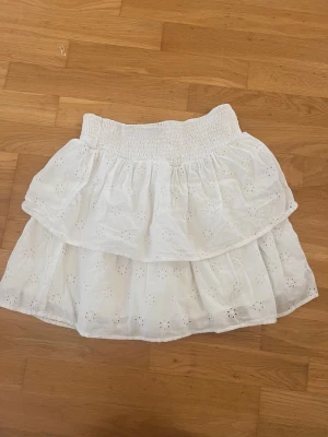 Vit kort kjol Gina Tricot  - Vit kjol spets och volanger i strl 170. Från Gina Tricot. Resår i midja. Material: bomull 