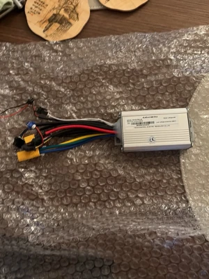 Kukirin g2 PRO controller  - Elektronisk styrenhet i silverfärgad metall med flera färgade kablar och kontakter. Perfekt för dig som gillar att bygga eller fixa elektronikprylar. Kompakt rektangulär form och tydliga anslutningar för enkel installation.