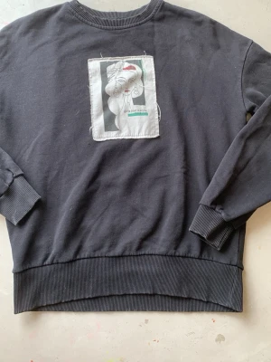 Svart tjocktröjan med snyggt tryck NA-KD - Fick av mammas kompis va inte min stil men sitter lite stor på mig som är 146