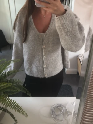 Ljusgrå stickad kofta med knappar - Mysig ljusgrå stickad kofta med v-ringning från gina jätte snygg passar allt och säljs inte längre från gina