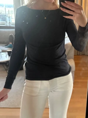 Svart långärmad topp - En stilren svart långärmad topp med rund halsringning. Toppen har en slim passform och är perfekt att matcha med både jeans och kjol. Materialet känns mjukt och följsamt mot kroppen. Enkel och tidlös design som funkar till många olika looks.