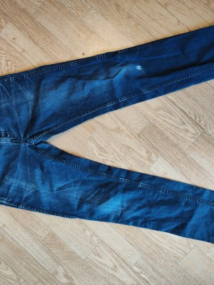 Mörkblå  jeans stl W28 L32 Levi's - Snygga mörkblå Levi's jeans. Perfekta för dig som gillar en enkel men stilren look. Dam stl W28 L32 Levi's. Ett litet hål finns på benet men annars fint skick. 