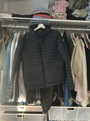 Stilren mörkblå dunjacka från Colmar - Snygg mörkblå pufferjacka från Colmar med huva och dragkedja framtill. Säljer då den är för liten! Nypris är 4000 mitt pris 2300, den är använd ett fåtal gånger så mycket bra pris. Hör av er vid frågor 