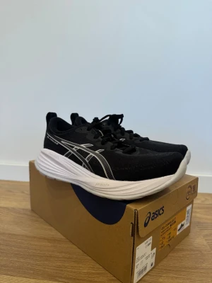 Svarta Asics GEL-Contend 8 sneakers - Svarta sneakers från Asics, modell GEL-Contend 8, med vita detaljer och logga på sidan. Skorna har en tjock, vit sula och är tillverkade i mesh och syntetmaterial för bra andningsförmåga. Skorna är enbart använda inomhus på gymmet. Kartong tillkommer.