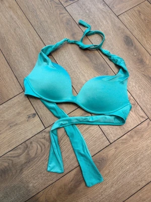 Turkos bikiniöverdel från Calzedonia - Snygg turkos bikiniöverdel från Calzedonia med vadderade kupor och knyt i nacken samt runt ryggen. Storlek 36/S. Ny utan prislapp och använd en gång men endast när jag solade. Nypris 500kr