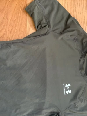 Underarmor comprison shirt - Underarmor comprison shirt i grön säljer på grund av att den inte passar mig längre för har blivit för stor för den. Skulle rekomdera för S och m elle runt xs till l för den är comprison så den tajtas ut