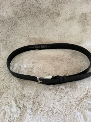 Premium Bvaldi Bälte  - Säljer ett basic svart skärp gjort av struts material från Bvaldi, tillverkat i äkta skinn och med en klassisk silverfärgad spänne. Skärpet är gjort i Italien och har en enkel, tidlös design