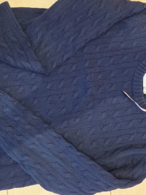 Mörkblå kabelstickad tröja Lindex - Mörkblå kabelstickad tröja från Holly & Whyte by Lindex. Klassisk rund halsringning och snyggt stickat mönster över hela tröjan. Perfekt för lager-på-lager och enkel att matcha med jeans eller kjol.