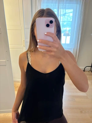 Svart linne - Säljer en svart linnetopp med tunna axelband och v-ringad. Den är inte genomskinlig då den har extra lager. Passar till allt. 