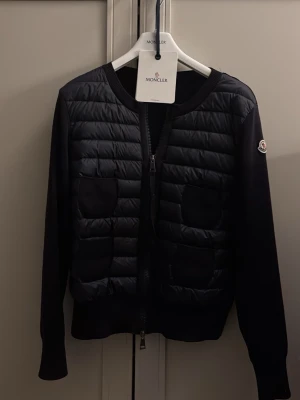 Svart cardiganjacka från Moncler - En jättefin moncler cardigan mörkblå i storlek s.  Köpt av en tjej här på Plick och använd nån gång. Nypris 9505kr köptes här på Plick för 5000 och säljer för 3900  skriv vid frågor ! 