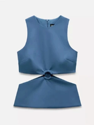 Blå ärmlös topp med ringdetalj - Snygg blå ärmlös topp med unik ringdetalj i midjan som skapar en cool cut-out effekt. Toppen har en rak halsringning och croppad passform, perfekt till jeans eller kjol. Materialet känns slätt och lätt, vilket gör den skön att bära under varma dagar.