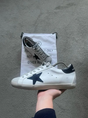 Golden Goose - Ett par skitsnygga Golden Goose i storlek 43!🌟 Mörkblå häl och Blå stjärna! De är i otroligt bra skick, bara använda ett fåtal gånger! OG Dustbag fås med! Kvitto/orderbekräftelse finns 🙏