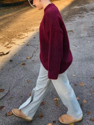 Vinröd stickad tröja Junkyard - Mysig vinröd stickad tröja från Junkyard i oversized modell med rund halsringning och långa ärmar. Tröjan har en rak passform och är tillverkad i ett mjukt, värmande material som passar perfekt till kyligare dagar. Tröjan är aldrig använd och har prislappen kvar.