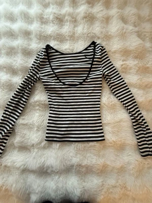 Randig långärmad topp med djup ringning - svartvit randig topp men öppen rygg från Gina tricot k storlek xs. Pris går att diskutera.