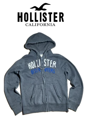 Hollister vintage hoodie - Hej! Säljer nu denna feta vintage Hollister hoodie. Tröjan är i storlek Medium och han på bilden är 185 och väger ca 70 kilo.  Tröjan har ett litet hål vid insidan, annars är den i utmärkt skick (se bild). Felet kan jag åtgärda innan de säljer, så de är bara att skriva om ni vill det. Skriv gärna om ni har några mer funderingar😊/Filip
