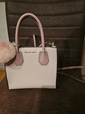 Ljusrosa handväska Michael Kors - Ljusrosa handväska med ett hjärta från Michael Kors. Knappt använd, i skick som ny. Pris kan diskuteras.