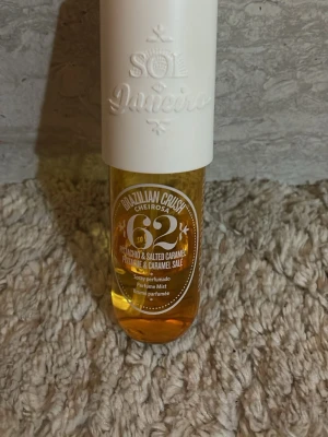 Sol de Janeiro Brazilian Crush 62 - Sol de Janeiro Brazilian Crush Cheirosa 62 är en parfymmist med doft av pistasch, saltad karamell och mandel. Flaskan är genomskinlig med guldfärgad vätska och ett vitt lock. Perfekt för dig som gillar söta och nötiga dofter.