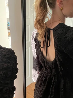 Svart klänning med öppen rygg - Säljer denna svarta klänningen med textur från ginatricot i storlek XS. Klänningen har öppen rygg med knyt- deltalj! Aldrig använd och prislappen kvar!