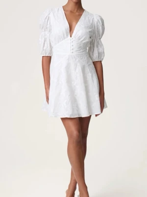 Studentklänning - Supersöt vit kort klänning med puffärmar och djup v-ringning. Klänningen har fina spetsdetaljer, knappar framtill och markerad midja. Perfekt för studnet och sommar!💕