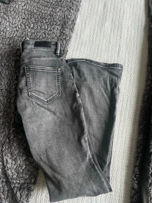 Gråa raka jeans från vero Moda  - Säljer ett par gråa jeans från vero Moda med klassisk femficksdesign och raka ben. Jeansen har en snygg tvättad look och är tillverkade i ett mjukt denimtyg som sitter skönt. Perfekta till en avslappnad stil.