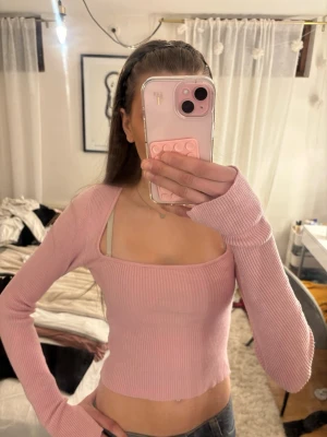 Rosa ribbad kroppad långärmad topp - Trendig ljusrosa croppad topp med långa ärmar och fyrkantig urringning. Toppen är ribbad och har en slim passform som framhäver figuren. Jätte skönt material.